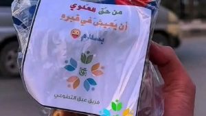 La photo montre un sac contenant un papier sur lequel est écrit "Alawi a le droit de vivre en paix dans sa tombe", que l'équipe de bénévoles d'Abaq a distribué aux habitants d'Idlib.