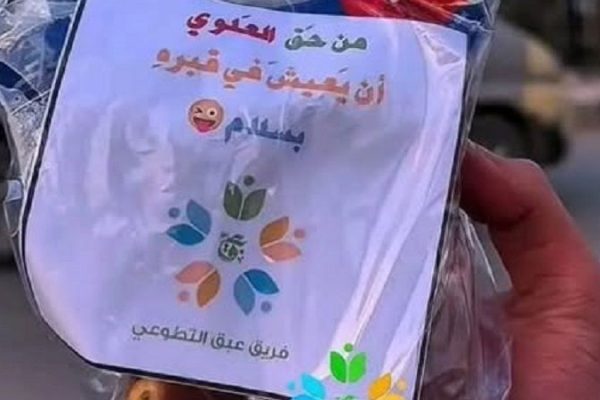 La photo montre un sac contenant un papier sur lequel est écrit "Alawi a le droit de vivre en paix dans sa tombe", que l'équipe de bénévoles d'Abaq a distribué aux habitants d'Idlib.