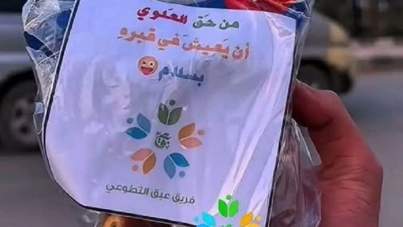 La photo montre un sac contenant un papier sur lequel est écrit "Alawi a le droit de vivre en paix dans sa tombe", que l'équipe de bénévoles d'Abaq a distribué aux habitants d'Idlib.